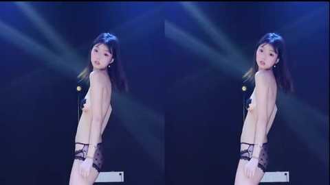 Video of a topless East Asian woman in black polka-dot panties, standing in front of a dark stage with blue and green lights.