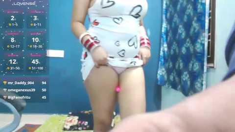 Video of a woman lifting her short white dress, revealing pink panties. Background features a calendar, blue wall, and a blue curtain.