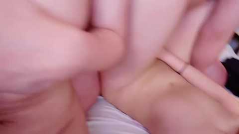 Video of two people engaged in sexual activity, featuring close-up, blurred faces and hands. One person's hand is on the other's genitals, with visible skin tones and slight blurriness.
