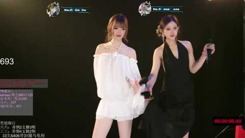 Video of two women, one in a white off-shoulder dress, the other in a black halter dress, holding hands, against a dark background with digital text and images.