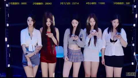 Video of five East Asian women in casual attire, including a red dress, plaid skirt, and jeans, holding smartphones, standing against a dimly lit background.