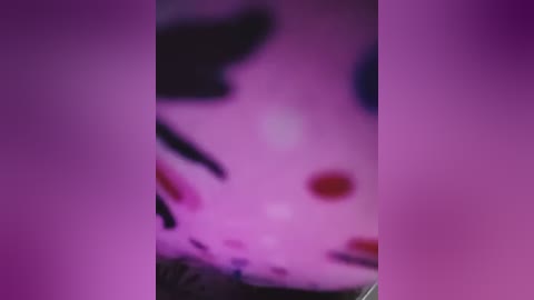 A blurred, pink-tinted video of a person, possibly female, with a focus on the face and neck area, showing dark hair and a hint of facial features.