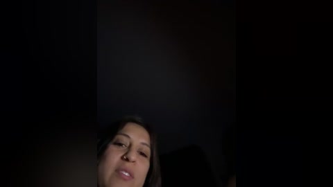 Video of a woman with long dark hair, light skin, and closed eyes, set against a dark background, creating a moody, intimate atmosphere.