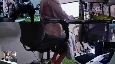 A video of a person in a beige hoodie, sitting at a cluttered desk with a black chair, surrounded by various items, including a dog, a computer monitor, and a cup.