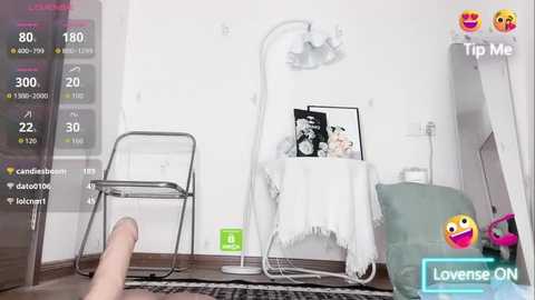 A digital image showing a woman sitting on a white chair, wearing a white shirt, with a black and white framed photo on a table, and a green drink bottle on the floor.