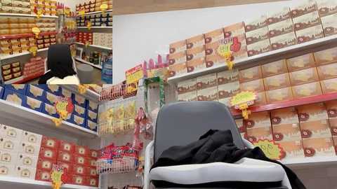 Video of a chaotic supermarket aisle with shelves filled with colorful boxes and packages, including an overturned shopping cart.