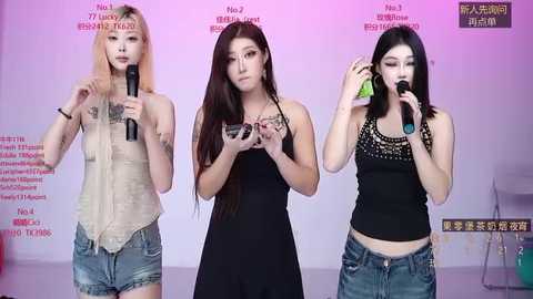 Video of three East Asian women, two with long hair, one with short hair, all dressed casually, singing into microphones, standing against a purple and white backdrop with Chinese text.