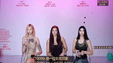 Video of three women in a studio, each wearing revealing outfits, holding microphones. Background features Chinese text and a pink-purple gradient.
