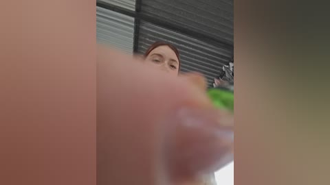 A low-angle video of a woman with light skin and red hair, looking down. The image is blurred, with a focus on her feet.