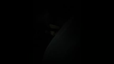 A dimly lit video of a dark, shadowy figure against a black background, possibly a person or animal, with indistinct features and indeterminate location, conveying a sense of mystery and intrigue.