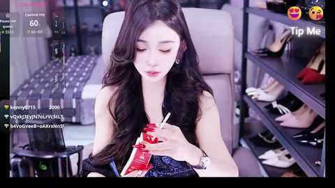 Video of an Asian woman with long black hair, wearing a sleeveless blue top, eating red ice cream with a pink spoon in a modern shoe store.