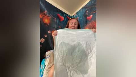 Video of a woman in a cozy room with a large, detailed wall mural depicting a forest scene, holding a white towel.