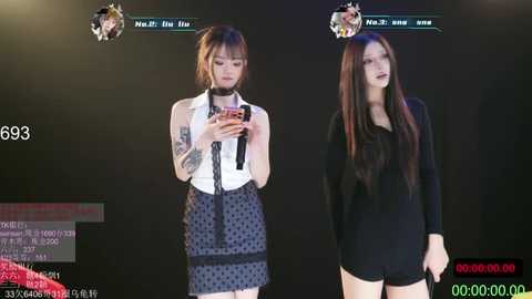 Video of two women in a virtual reality headset, one in a white sleeveless top and polka-dot skirt, the other in a black long-sleeve top and shorts, with a black background.