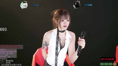 Video of a young Asian woman with dark hair, wearing a white sleeveless blouse, black lace top, and red skirt, singing into a microphone against a dark background, with various on-screen text and graphics.