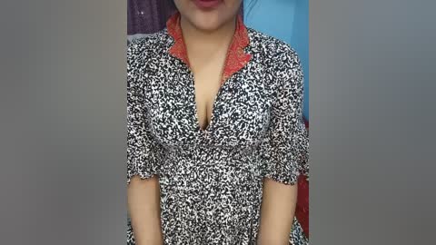 Video of a woman in a leopard print dress with a red lace collar, standing against a blurred background.