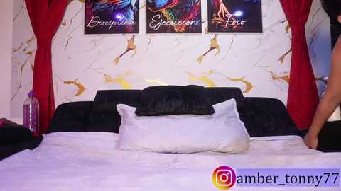 Video of a luxurious bedroom with a black velvet bed, white pillows, red drapes, abstract wall art, and a watermark \"amber_tonny77\".