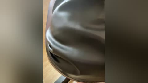 Video of a sleek, metallic, egg-shaped object with a smooth, reflective surface, positioned on a wooden surface. The image is slightly blurred, creating a soft, dreamy effect.