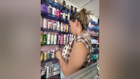 Video of a plus-sized woman with blonde hair in a ponytail, wearing a plaid top and light pants, browsing a cosmetic aisle with shelves full of various skincare products.