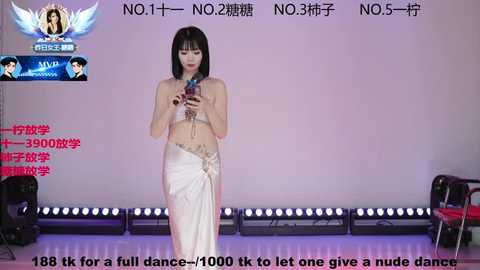Video of an East Asian woman with straight black hair and fair skin, topless, wearing a white cloth wrapped around her waist, holding a microphone, standing on a stage with blue lights and Chinese text.