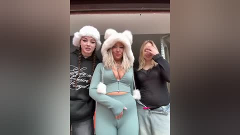 Video of three women in animal-themed winter hats and matching outfits, standing outside a building.