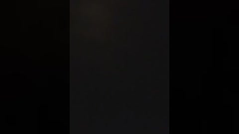 Video of a dimly lit, vertical black column against a dark background, with a slight hint of light reflecting off the column's surface, creating a subtle contrast. The image lacks visible details or colors, focusing on the column's shadowy texture.