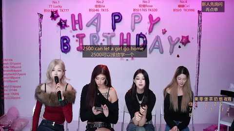 Video of four young Asian women in casual attire singing into microphones, against a purple and pink \"Happy Birthday\" backdrop.