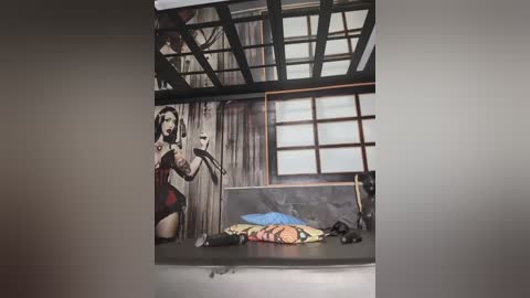 Video of a modern, minimalist room with a mural of a woman in a red dress on the wall. The room features a large window, a bed with colorful pillows, and a grey metal frame.