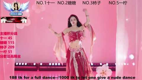 A vibrant video of an Asian woman in a red belly dance costume, adorned with gold accents, performing on stage. The background is a pink-hued, lit dance floor. Text overlay details her dance score and ranking.