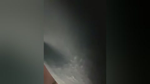 A video captures a dramatic sky with a large, ominous cloud partially obscuring a bright, reddish-orange sun setting in the background. The cloud is dark and dense, contrasting with the vibrant colors of the sunset.