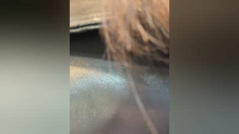 A close-up video of a woman's face, featuring long, blonde hair cascading over a dark, leather jacket. The image is slightly blurred, with a soft focus and muted colors.