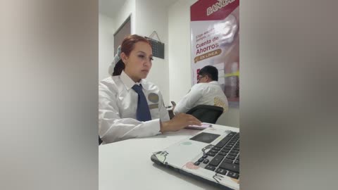 Video of two female doctors in white lab coats and blue ties, sitting at desks in a clinical office.