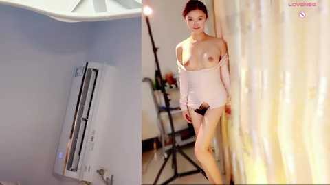 Video of a nude Asian woman with small breasts, standing in a studio next to a white backdrop and a large studio light.