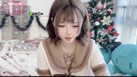 Video of an Asian woman with shoulder-length brown hair, wearing a sailor-style school uniform, playing with a plush toy in a festive, decorated bedroom.