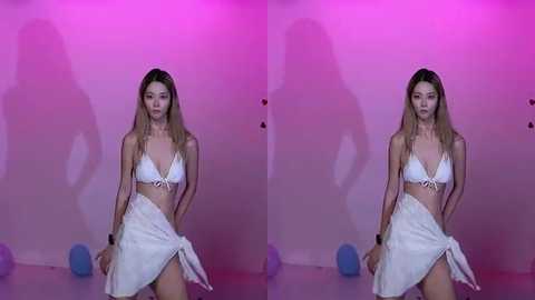 A video of an Asian woman with long, straight, blonde hair, wearing a white bikini, posing against a pink-lit background. She holds a white sarong, looking confident.