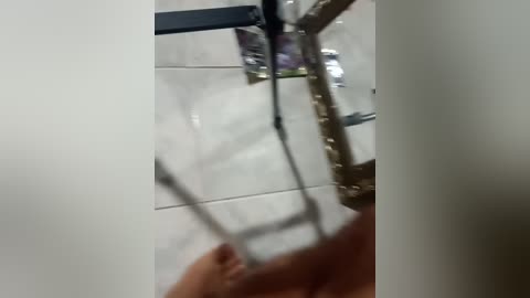 A video shows a close-up of a hand tightening a metal bolt on a bicycle frame, partially obscured by a white background.