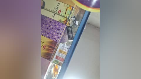 A video of a supermarket shelf displaying various snack packages, including colorful chips and candy bars. The background is a neutral beige wall, and the lighting is soft.