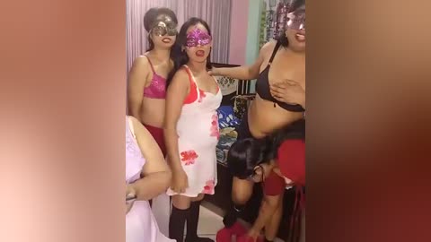 Video of three women in lingerie, two with red bras and white dresses, one with black lingerie, in a dimly lit room.