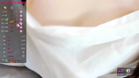 A video of a woman's bare, pale, large breast, partially covered with a white sheet, displayed on a smartphone screen with chat bubbles and emojis.