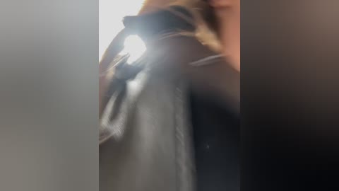 A video showing a close-up of a black cat with a white belly, partially blurred, against a dark background. The cat's fur is smooth and shiny.