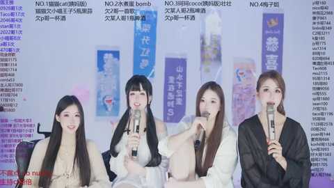 Video of four Asian women with long black hair, wearing white robes, sitting and holding microphones. Background has Chinese text and images, indicating a promotional or media event.
