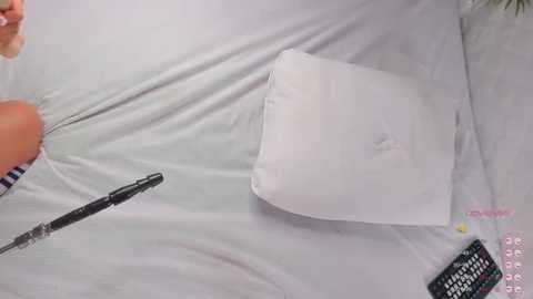 A video showing a person writing with a pen on a white bedsheet. A calculator and a partially visible hand with striped socks are also visible.