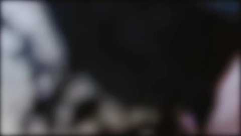 This blurred, low-resolution image appears to depict a close-up of a person's face, with indistinct features and a dark background. The image lacks detailed texture and color, making it difficult to discern specific details.