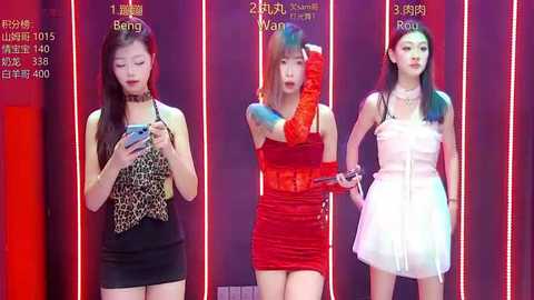 Video of three Asian women with long hair in vibrant, contrasting dresses against a red-lit background. Left: black dress with leopard print, middle: red lace dress, right: white tulle dress.