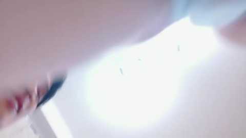 A blurry video of a naked torso with a pale complexion and small, erect nipples, highlighting a soft, smooth texture. The background is out of focus, creating a dreamy, ethereal ambiance.