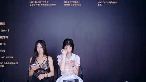 Video of two Asian women in black lace dresses sitting side by side, looking away, against a dark background with Chinese text.