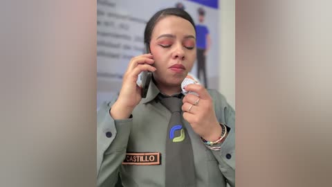 Video of a woman in a green uniform, holding a phone and cigarette, with a blurred background.