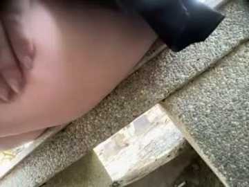 Video of a person's partially visible head and torso on a textured, beige carpet. The person's hand rests on the carpet, and a black object, possibly a camera or phone, is in the foreground.