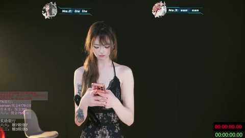 Video of a young woman with long brown hair in a black floral dress, holding a phone, with on-screen text in Korean.