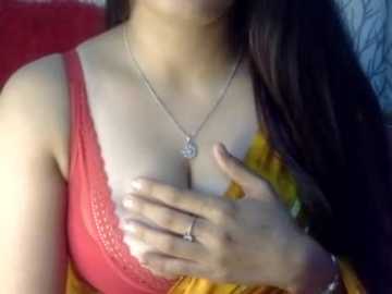 Video of a woman with fair skin, wearing a red lace bra, a gold necklace with a pendant, and a yellow blouse, with her hands covering her chest.
