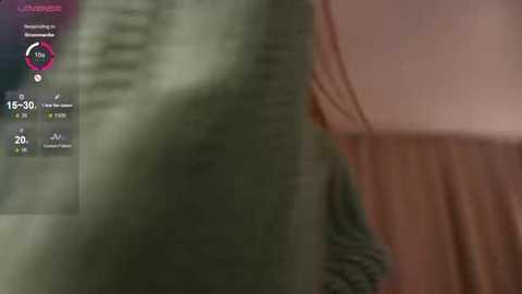 A blurred video of a person standing with a green curtain in the foreground, displaying a digital health monitor with vital signs.